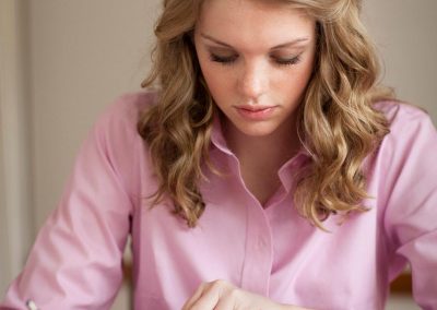 girl in pink shirt reading Book of Mormon